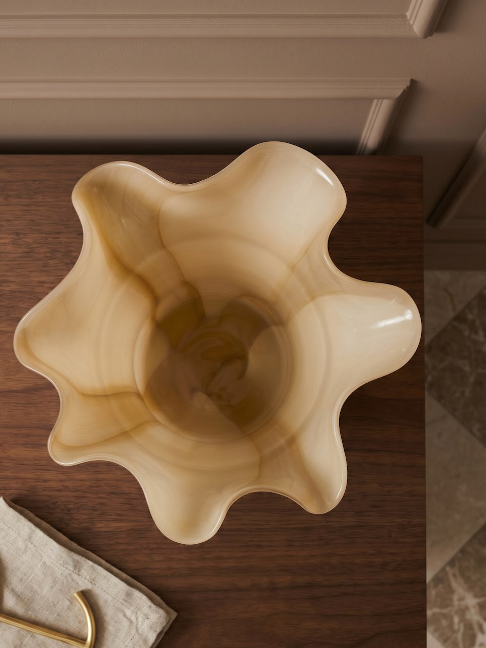 Decorative beige vase on a wooden surface
