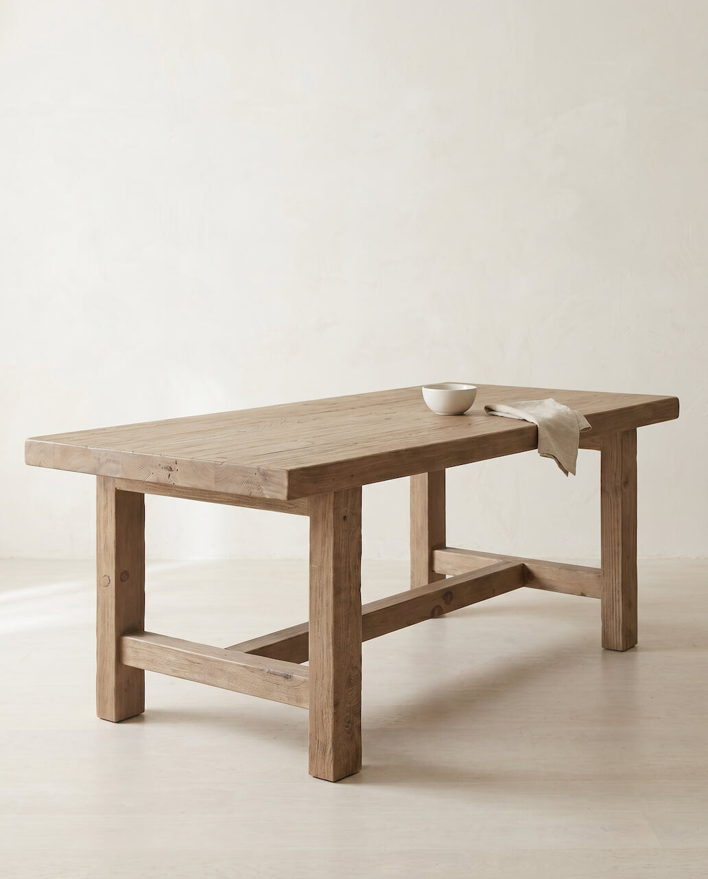 Wooden table with a white bowl on a plain background