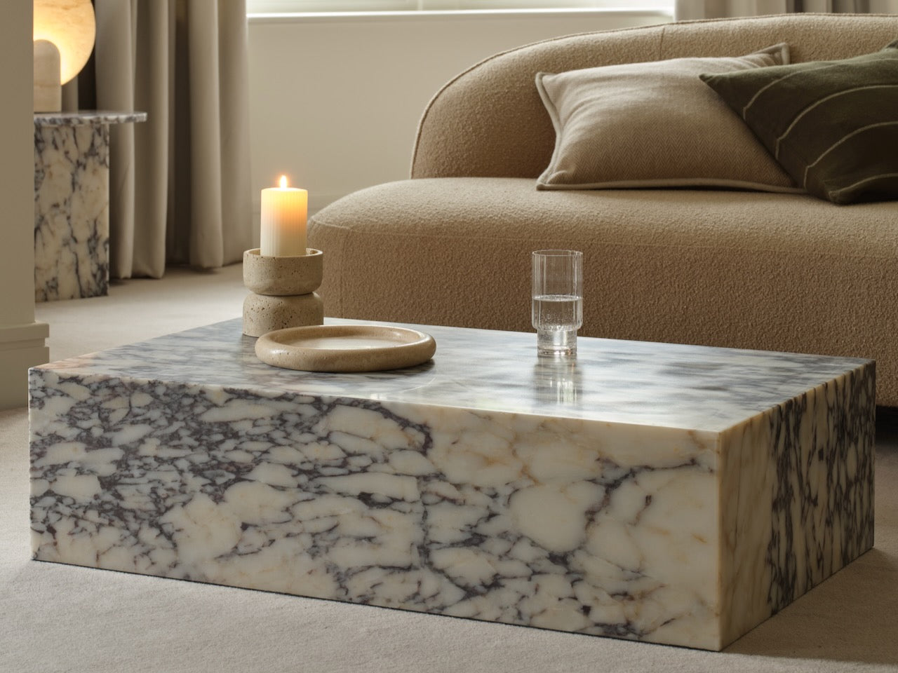 Marble coffee table with a candle and glass in a living room setting
