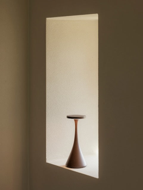 Bora corten rechargeable lamp on a white plaster windowsill