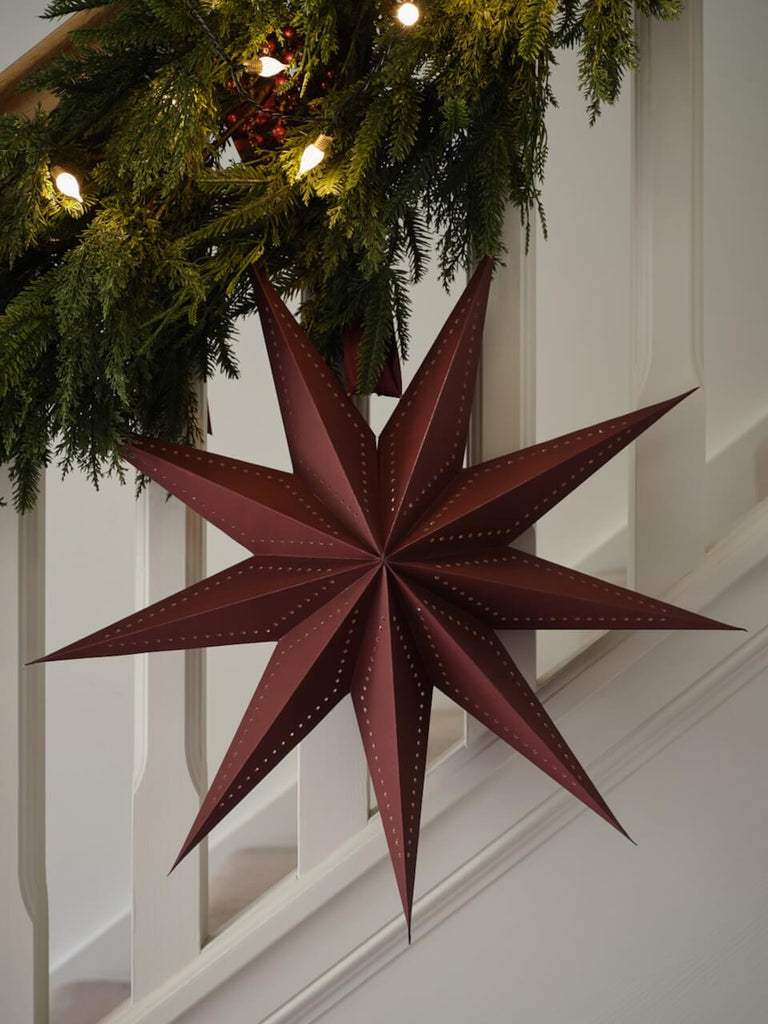 Burgundy Paper Star Decoration hanging on staircase.