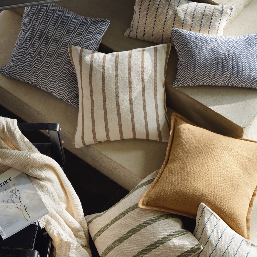 Array of striped cushions, plain cushions and herringbone cushions from Layered Lounge 