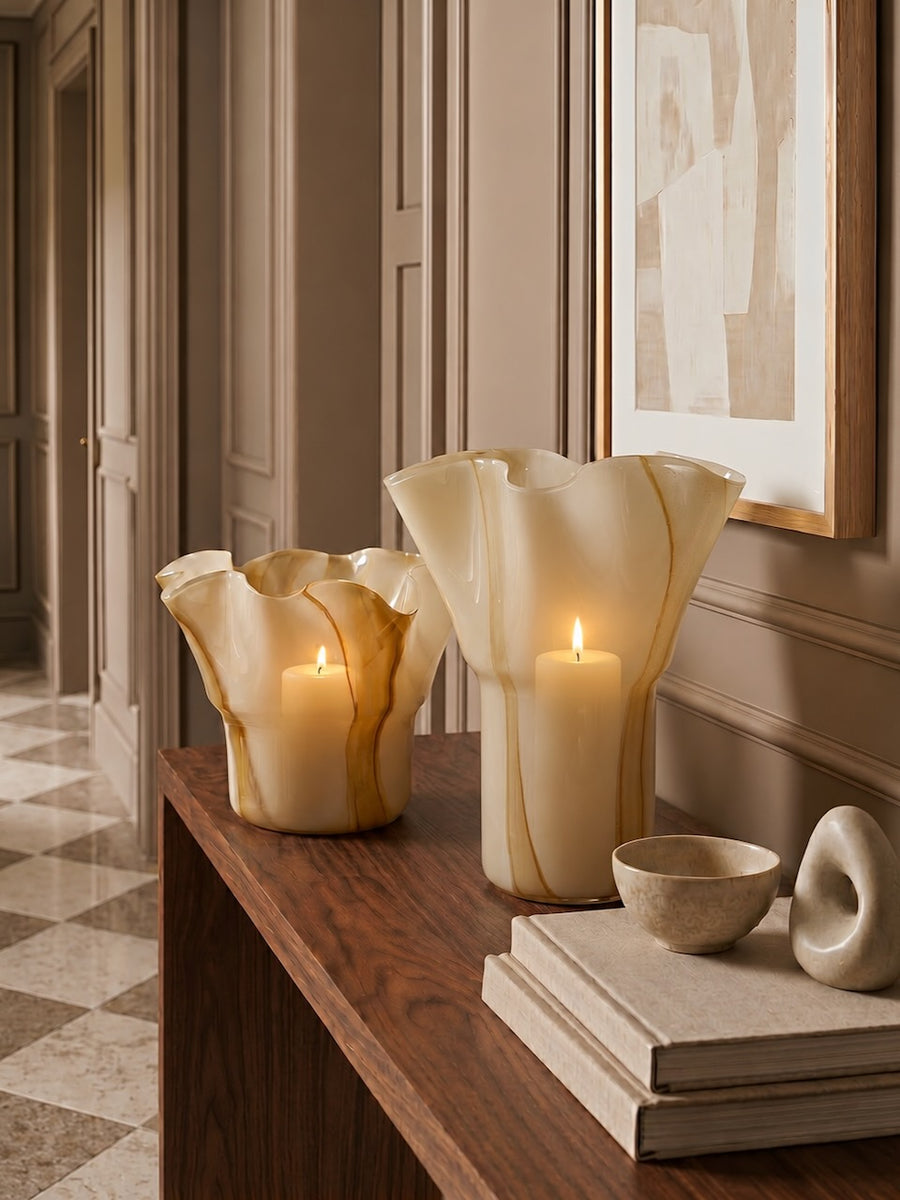 Decorative candles and vases on a wooden surface with a neutral color scheme.
