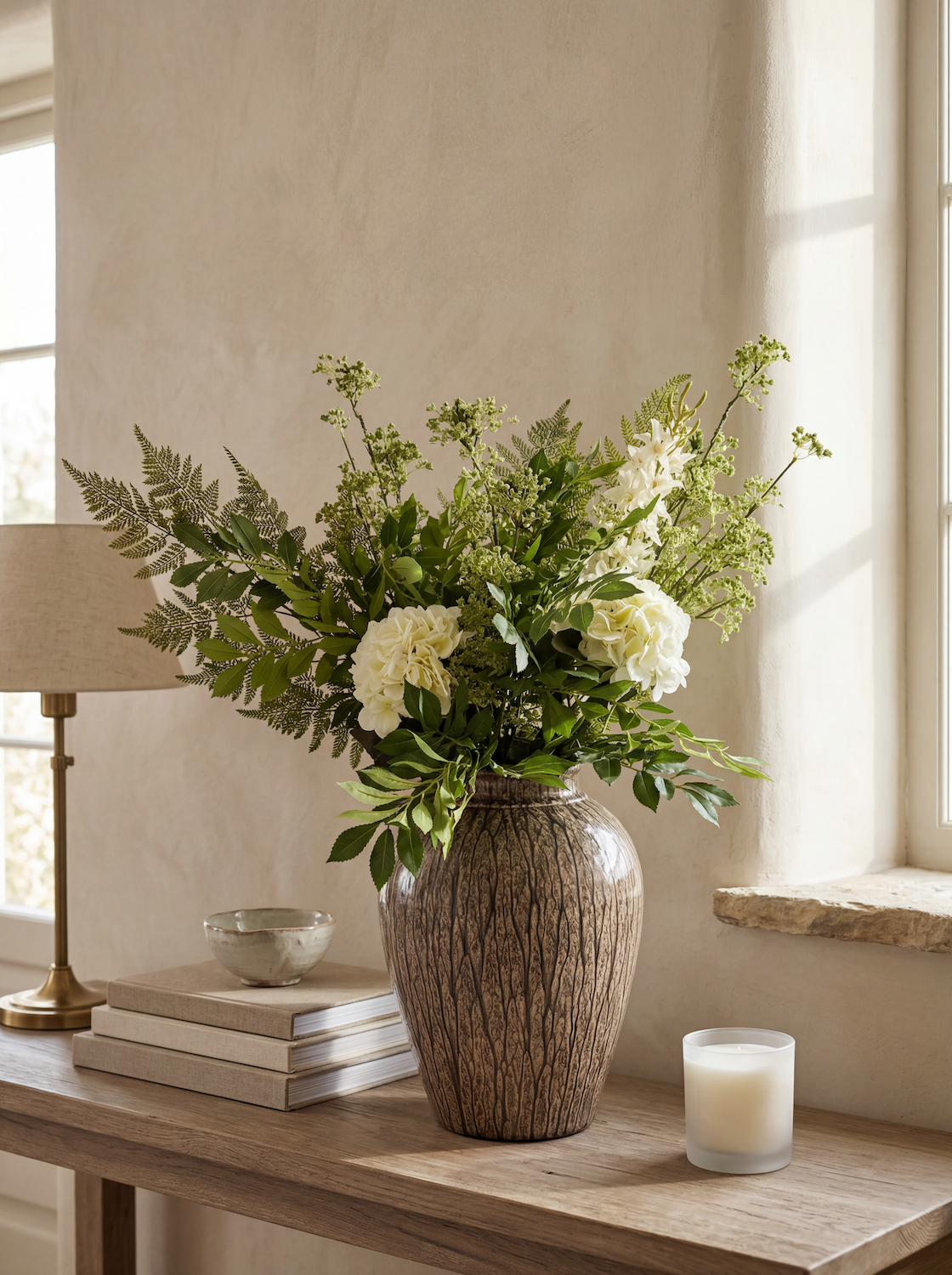 Decorative vase with flowers on a wooden table in a bright room