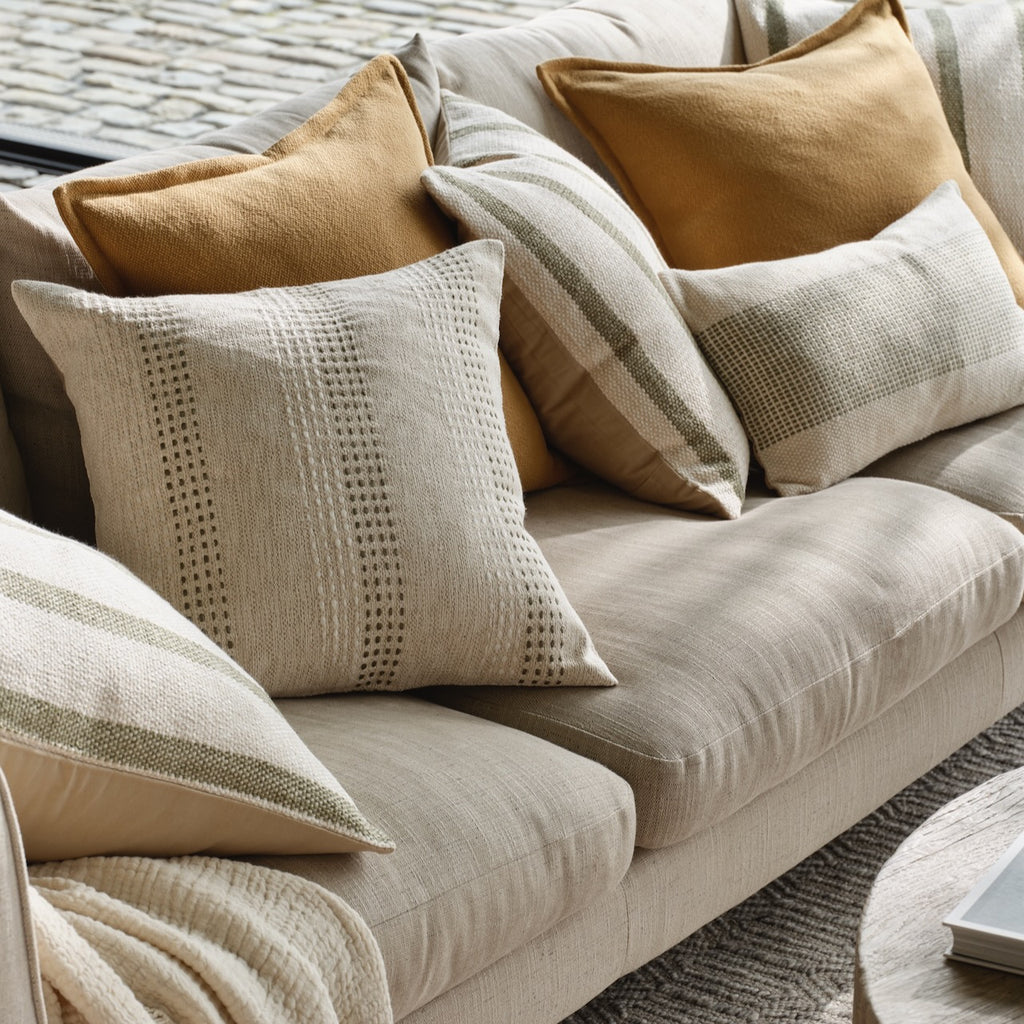 Collection of Layered Lounge Cushions on a neutral sofa. 