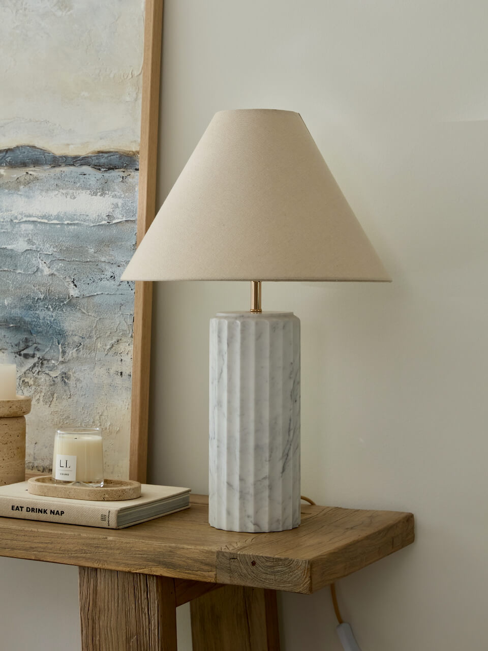 Marble-textured table lamp on a wooden surface with a neutral background
