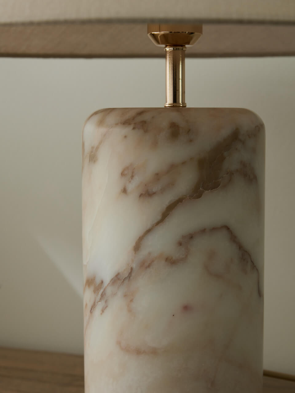 Marble-textured lamp base with gold fixture on a neutral background