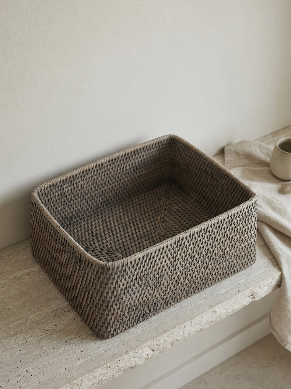 Grey wash rattan basket detail in a warm interior